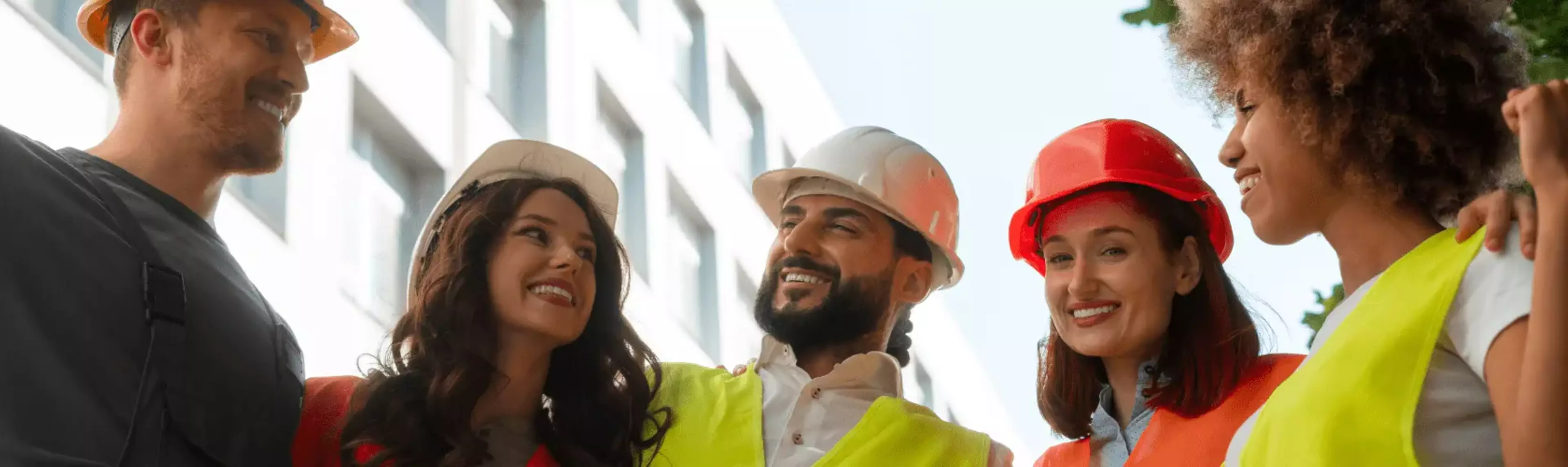 Construction members standing in a line looking at the camera smiling for a photo.