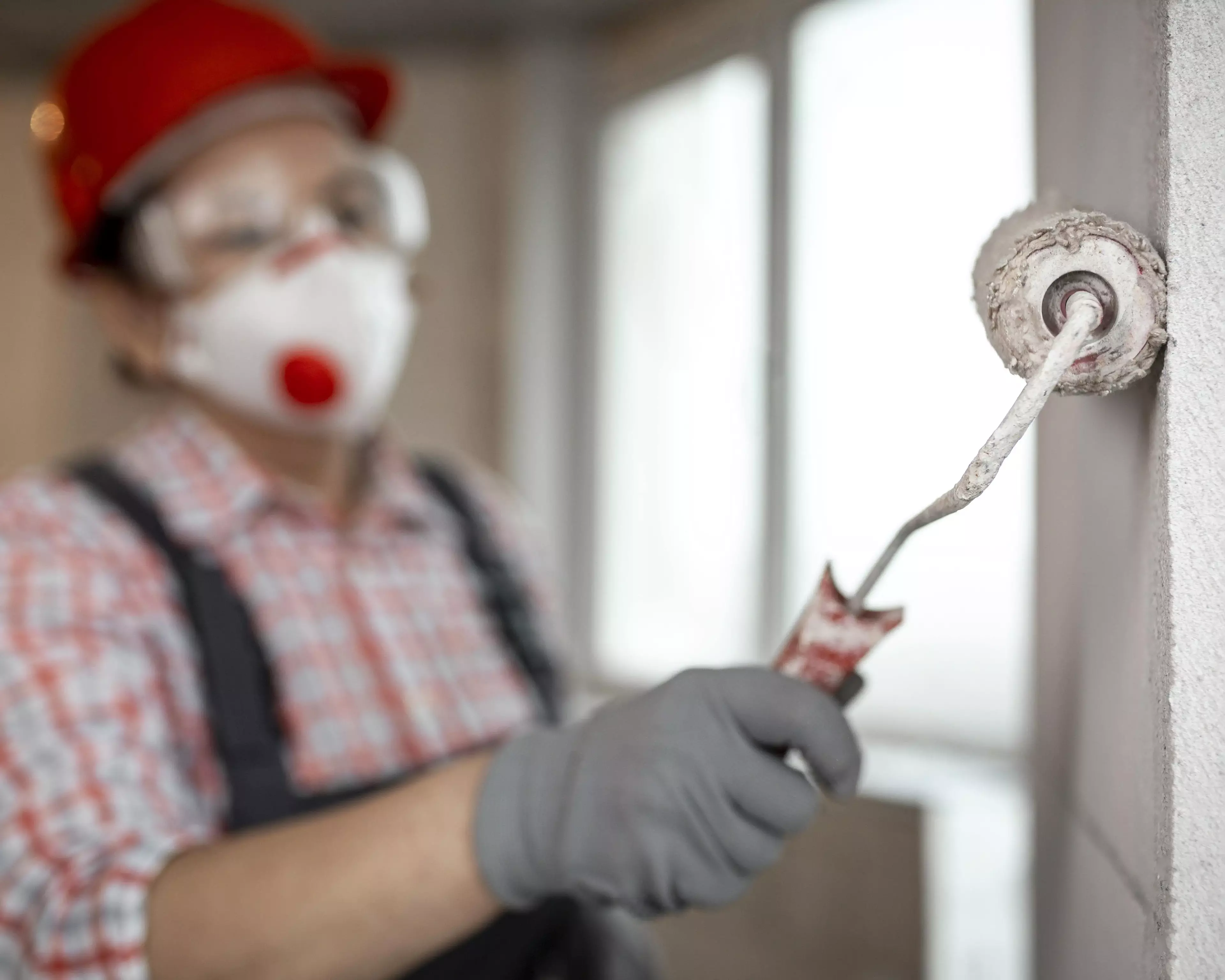 Construction worker painting a wall.