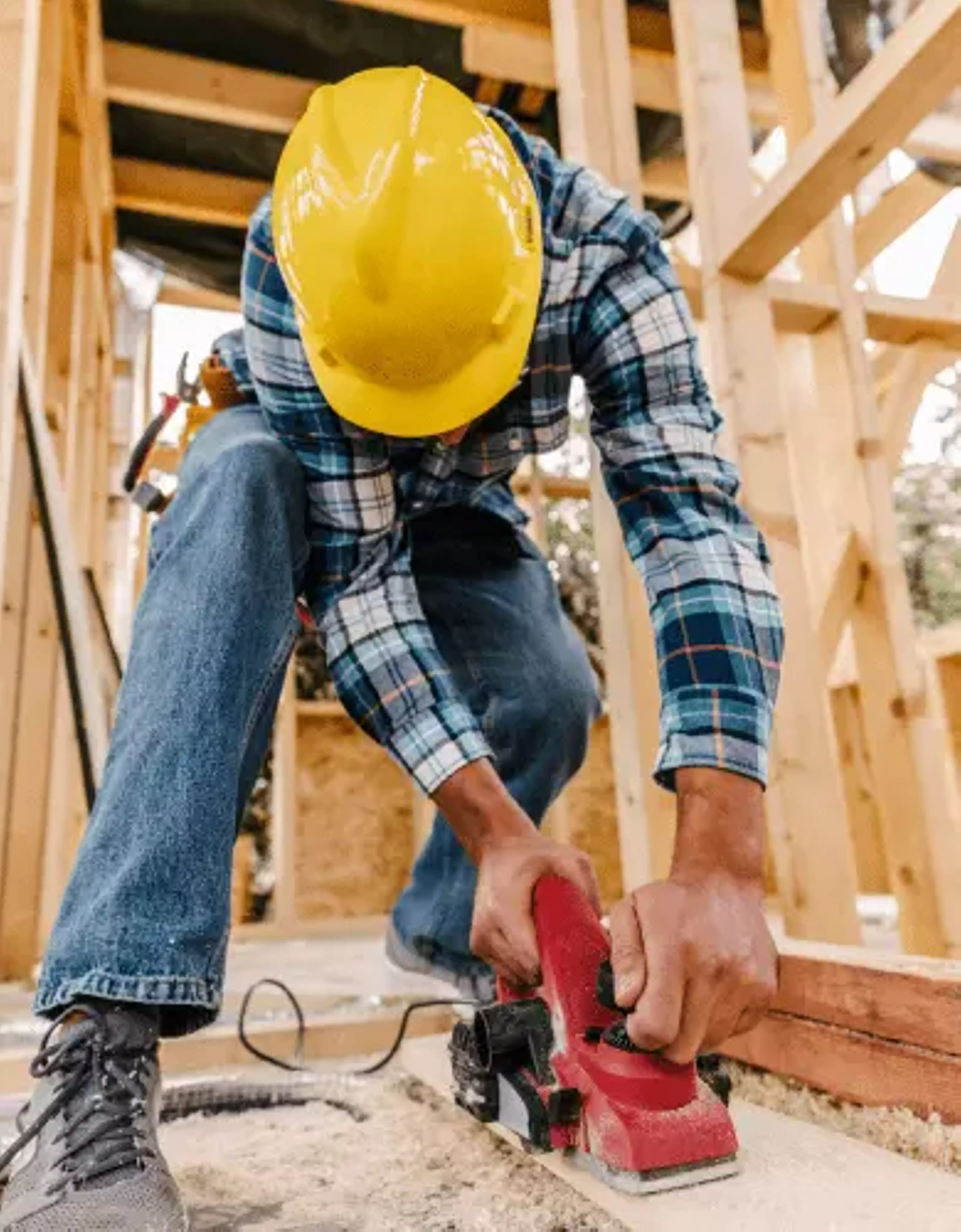 construction worker sanding wood.