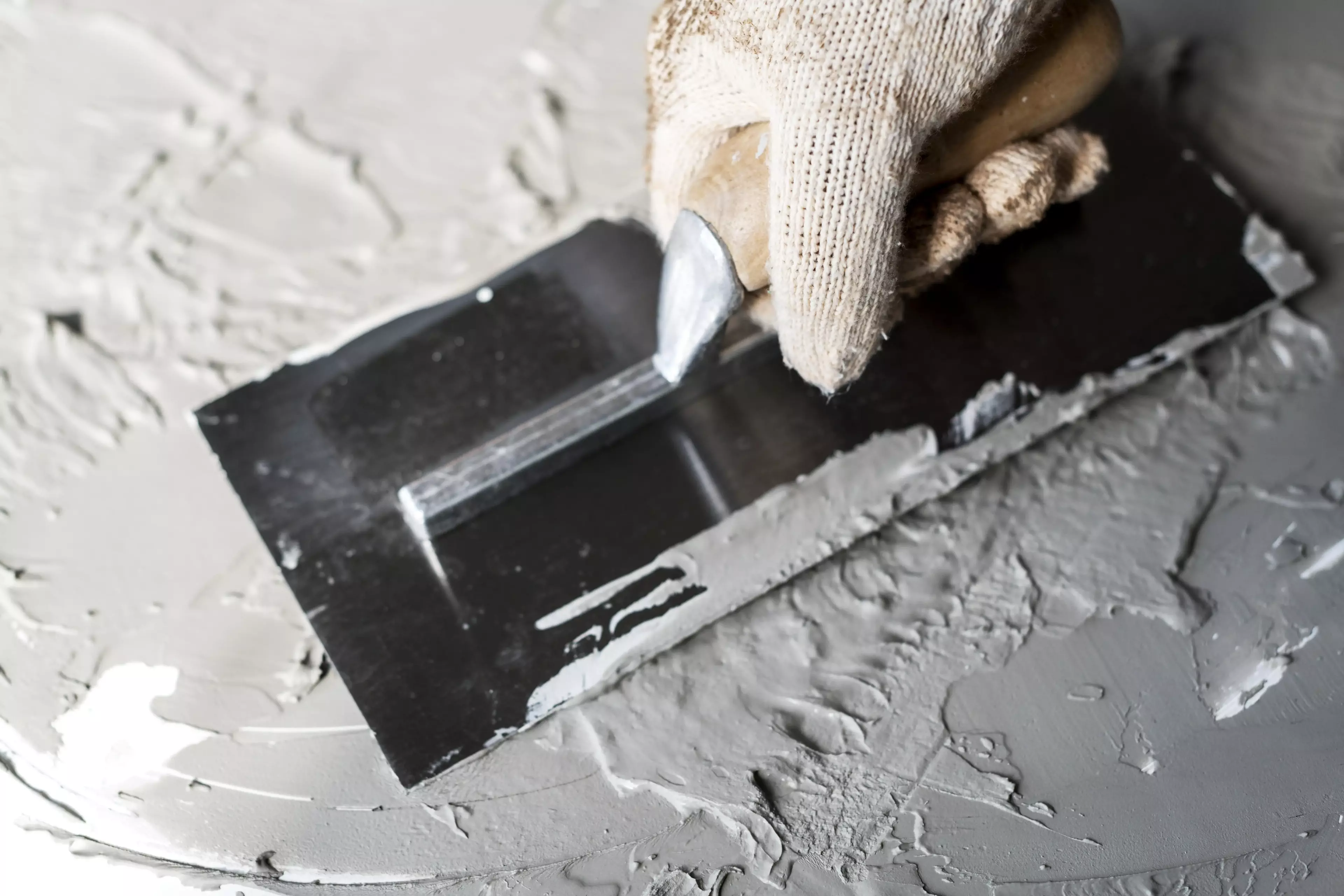 Hand applying drywall.