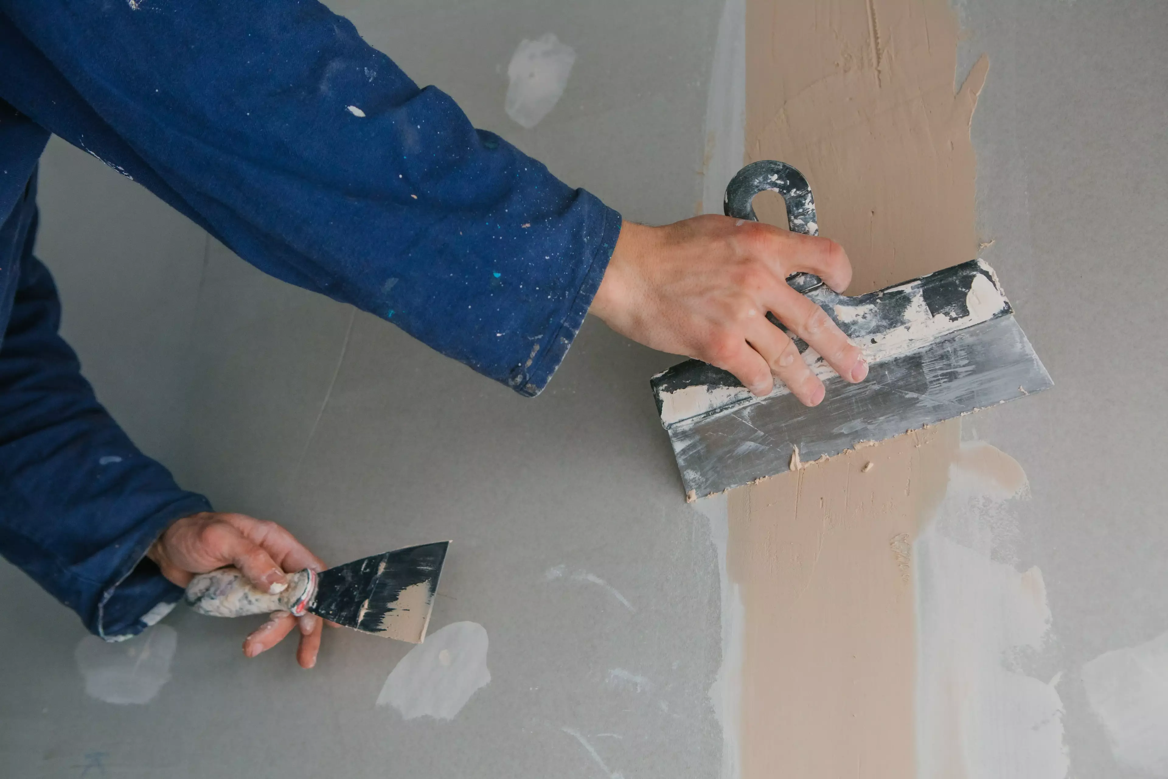 Man adding plaster to wall.